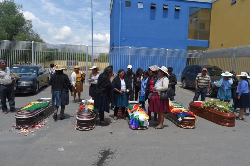 Relatives stand next to coffins of supporters of former Bolivian President Morales in Cochabamba