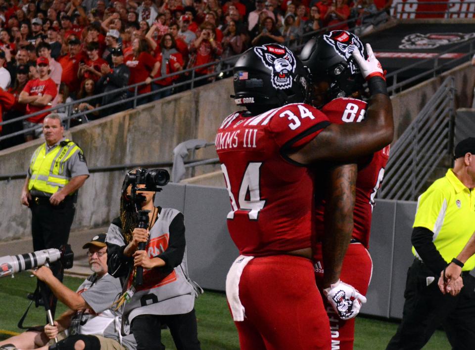 Sep 24, 2022; Raleigh, North Carolina, USA;North Carolina State Wolfpack wide receiver Devin Carter (88) is greeted by teammate Delbert Mimms III (34) after scoring a touchdown during the first half against the Connecticut Huskies at Carter-Finley Stadium. Mandatory Credit: Rob Kinnan-USA TODAY Sports