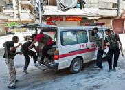 Syrian rebel fighters load a wounded person into an ambulance during clashes with Syrian government forces in the al-Sahur district in Aleppo. President Bashar al-Assad vowed on Tuesday to crush the 17-month rebellion against his regime and to cleanse Syria of "terrorists," as his troops engaged rebels in key battleground city Aleppo