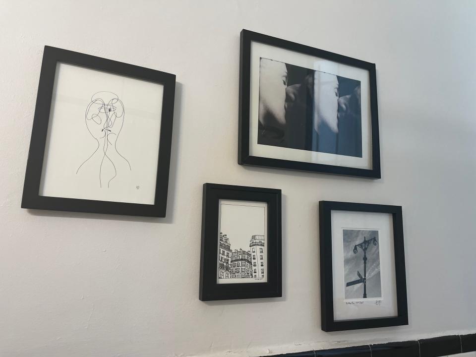 Black and white photography and illustrations in black frames hanging from wall