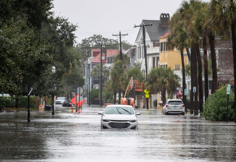 A car drives through a flooded street on Dec. 17, 2023, in Charleston, S.C.