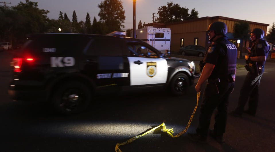 A Sacramento Police vehicle passes a roadblock near a home that authorities have surrounded where an armed suspect has taken refuge after shooting a Sacramento police officer, Wednesday, June 19, 2019, in Sacramento, Calif. (AP Photo/Rich Pedroncelli)