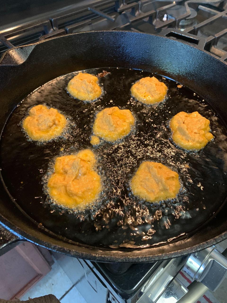 a pan of fritters frying in oil