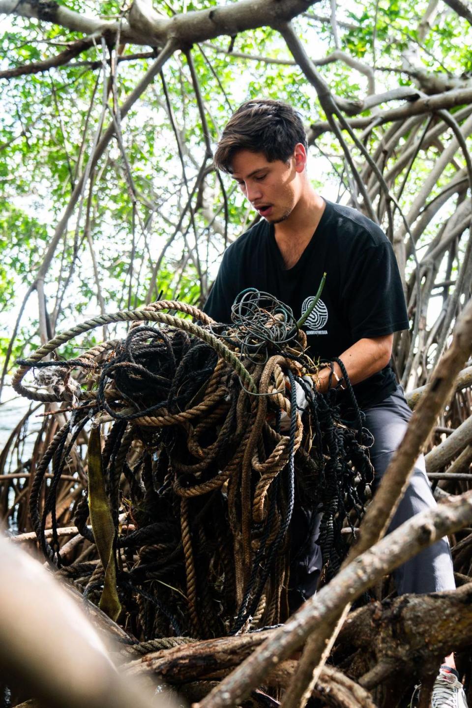 Sendit4thesea Rodolfo Rojas holds a clump of rope and wires that he removed from the mangroves at Kennedy Park in Coconut Grove.