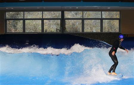Lauren McLean tests the waves on a surfboard at the still under-construction Surf's Up indoor water and surf park in Nashua, New Hampshire November 15, 2013. REUTERS/Brian Snyder