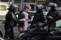 Police officers detain a demonstrator during a banned protest in support of Palestinians in the Gaza Strip, Saturday, May, 15, 2021 in Paris. Marches in support of Palestinians in the Gaza Strip were being held Saturday in a dozen French cities, but the focus was on Paris, where riot police got ready as organizers said they would defy a ban on the protest. (AP Photo/Michel Euler)