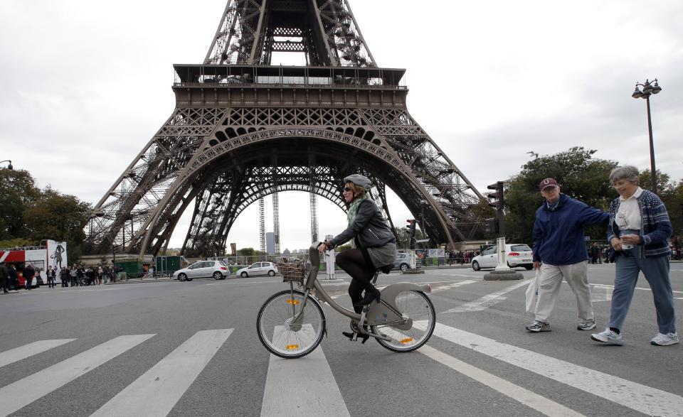 A woman rides a Velib bike-sharing program closed to the Eiffel Tower, seen in background, in Paris, Tuesday, Oct. 30, 2012. From London’s “cycle superhighways” to popular bike-sharing programs in Paris and Barcelona, growing numbers of European cities are embracing cycling as a safe, clean, healthy, inexpensive and even trendy way to get around town. (AP Photo/Francois Mori)