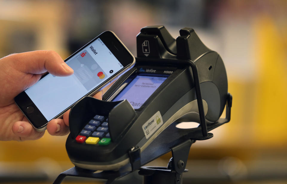  A smartphone is held at the payment terminal at the checkout of a supermarket.