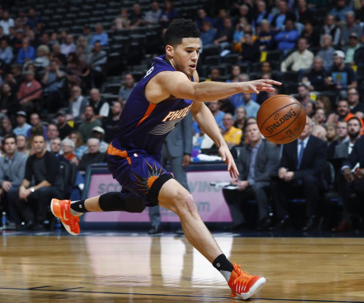 Devin Booker reaches for the ball in Wednesday's loss. (Associated Press)