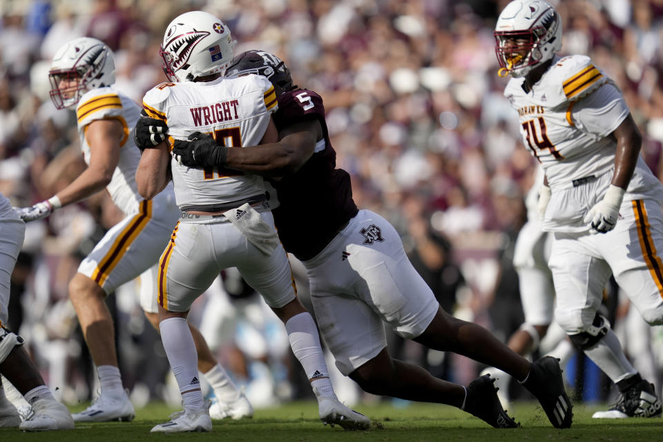 Texas A&M defensive lineman Shemar Turner (5) sacks Louisiana-Monroe quarterback Jiya Wright, front left, for a five-yard loss during the second quarter of an NCAA college football game Saturday, Sept. 16, 2023, in College Station, Texas. (AP Photo/Sam Craft)