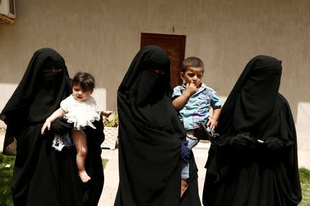 Wahida (C), 28, the wife of Azzedine Zaini, who was killed during a U.S. air strike in Libya, carries her son Bara'ah, 2, as she stands with Rahma (R), 17, the wife of Noureddine Chouchane, who was also killed during a U.S. air strike in Libya, and her sister Gofran, 18, (L) who carries her six-month-old daughter after their interview with Reuters in Maitiga prison in Tripoli, Libya, May 31, 2016. REUTERS/Zohra Bensemra