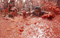 <p>People lie in a puddle of squashed tomatoes, during the annual “tomatina” tomato fight fiesta, in the village of Bunol, 50 kilometers outside Valencia, Spain, Aug. 31, 2016. (Photo: Alberto Saiz/AP)</p>