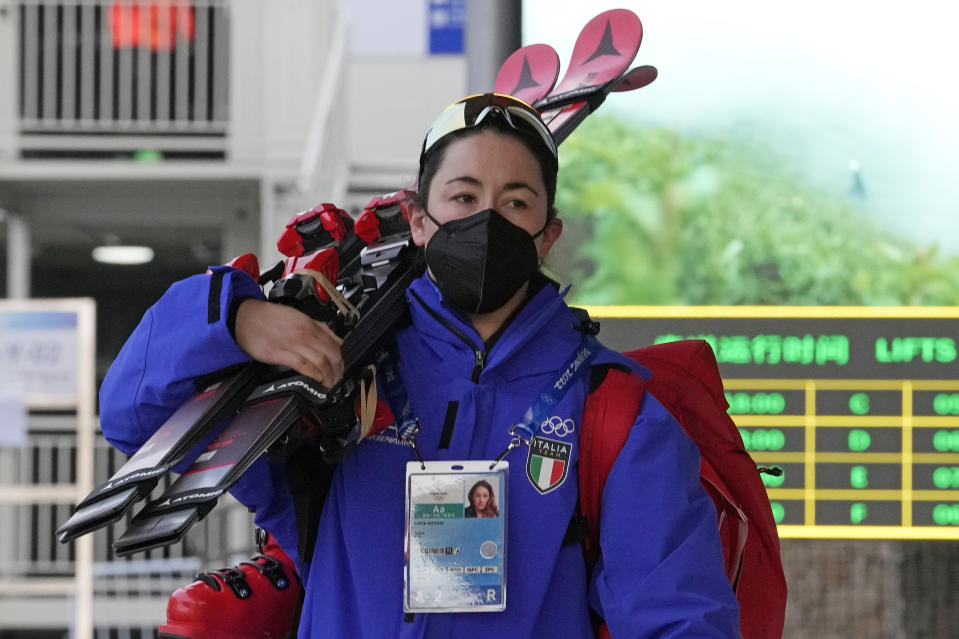 Italian skier Sofia Goggia walks toward the gondola to take her up the mountain at the alpine skiing venue at the 2022 Winter Olympics, Wednesday, Feb. 9, 2022, in the Yanqing district of Beijing. Goggia, who won the Olympic downhill four years ago in Pyeongchang, arrived late to China after crashing and injuring her left knee and leg last month. (AP Photo/Luca Bruno)