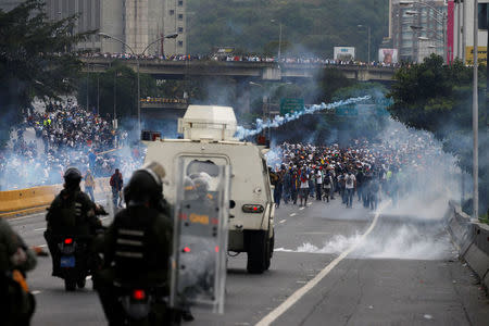 FILE PHOTO: Police fire tear gas toward opposition supporters during clashes while rallying against Venezuela's President Nicolas Maduro in Caracas, Venezuela. REUTERS/Carlos Garcia Rawlins