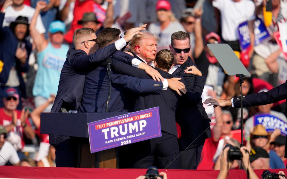 Security guards held on to Trump and led him to an armoured car