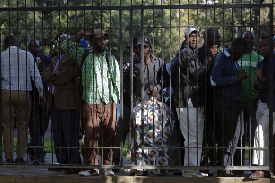 Supporters watch from the street a press conference by opposition leader Nelson Chamisa gets underway in Harare, Zimbabwe, Friday Aug. 3, 2018. Hours after President Emmerson Mnangagwa was declared the winner of a tight election, riot police disrupted the press conference where opposition leader Nelson Chamisa was about to respond to the election results. (AP Photo/Jerome Delay)