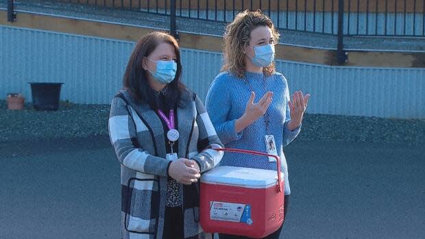 Nurses from the Fraser Health Authority stand in front of the Katzie health center as community leaders sing and drum to welcome them and the vaccine to the Katzie First Nation near Pitt Meadows, B.C. 