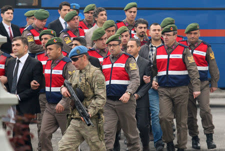 Turkish soldiers accused of attempting to assassinate President Tayyip Erdogan on the night of the failed last year's July 15 coup, are escorted by gendarmes as they arrive for the first hearing of the trial in Mugla, Turkey, February 20, 2017. REUTERS/Kenan Gurbuz