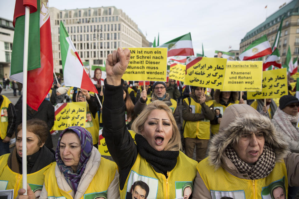 <p>Protesters hold signs and flags of the Iranian consitutional monarchy era as they protest near Brandenburg Gate in Berlin, Germany, Jan. 6, 2018. (Photo: OMER MESSINGER/EPA-EFE/REX/Shutterstock) </p>