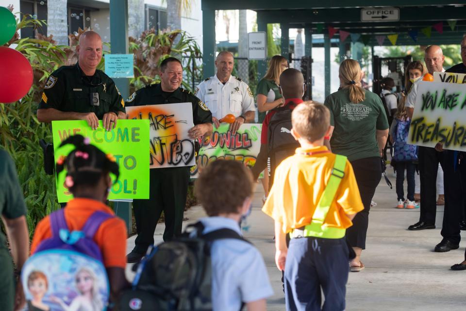 St. Lucie County Sheriff's Sgt. Matthew Woods (from left), Lt. Keith Pearson, and (former) Chief Deputy Brian Hester welcome Rivers Edge Elementary School students back for the first day of school during the annual Tunnel of Hope on Tuesday, Aug. 10, 2021, in Port St. Lucie. "It reenergizes us as law enforcement to see the kids coming back," Pearson said, adding that the Tunnel of Hope will be happening across the school district all week. "We try to break that mold of kids being afraid of cops."