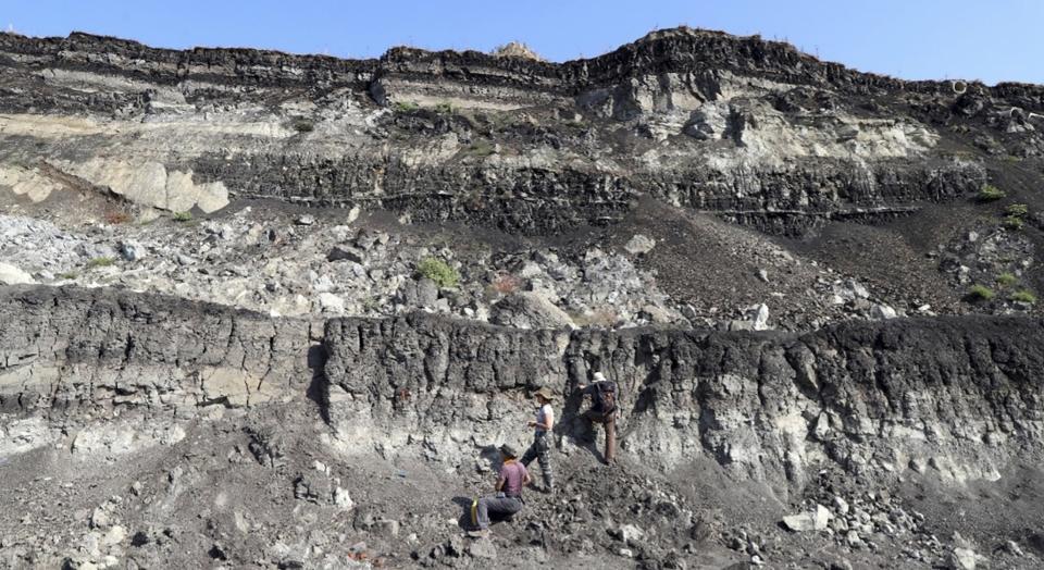 This undated photo provided by the Greek Culture Ministry on Thursday, June 1, 2023 shows researchers on the sides of an open coal mine in Megalopolis, southern Greece. The Culture Ministry said that a five-year international project in Megalopolis has uncovered the oldest-known archaeological site in the country that dates to about 700,000 years ago, pushing back the dawn of Greek archaeology by up to 250,000 years. (Greek Culture Ministry via AP)