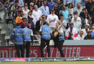 Security officials remove a pitch invader. (AP Photo/Aijaz Rahi)