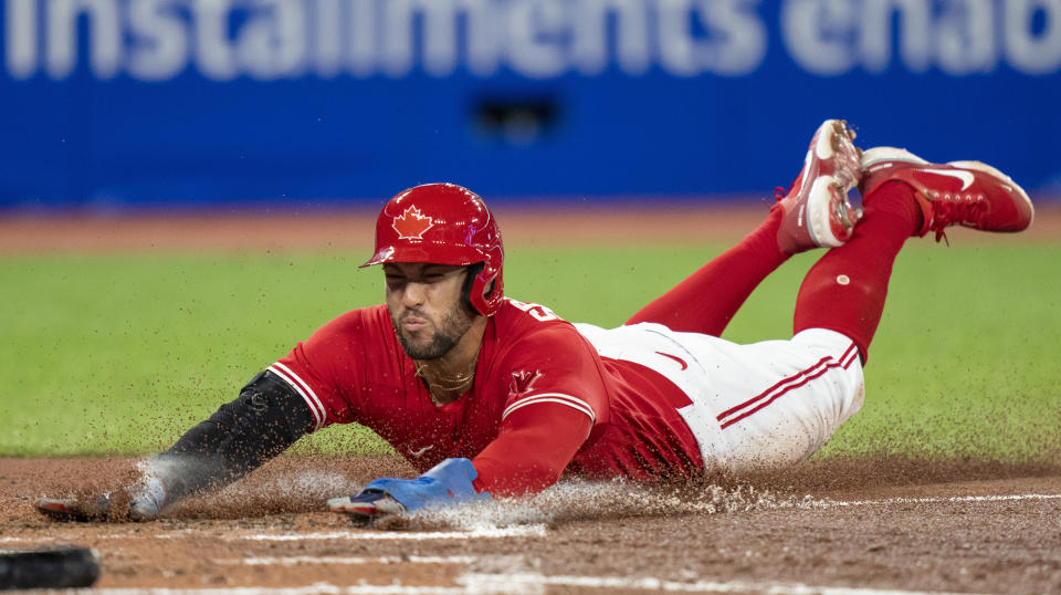 Toronto Blue Jays center fielder George Springer slides in to score on the Tampa Bay Rays during fourth inning of a baseball game in Toronto, Monday, Sept. 12, 2022. (Frank Gunn/The Canadian Press via AP)