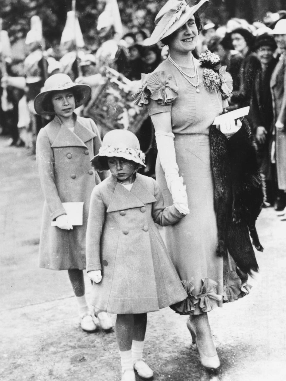 The nine-year-old Elizabeth attends an aristocratic wedding in 1936 with her mother and younger sister. Later in that year, with the death of her grandfather and the abdication of her Uncle Edward VIII, she became first in line to the throne (Getty)
