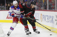 New York Rangers left wing Phillip Di Giuseppe (33) chases the puck against Carolina Hurricanes defenseman Jake Gardiner (51) during the first period of an NHL hockey game in Raleigh, N.C., Friday, Feb. 21, 2020. (AP Photo/Gerry Broome)