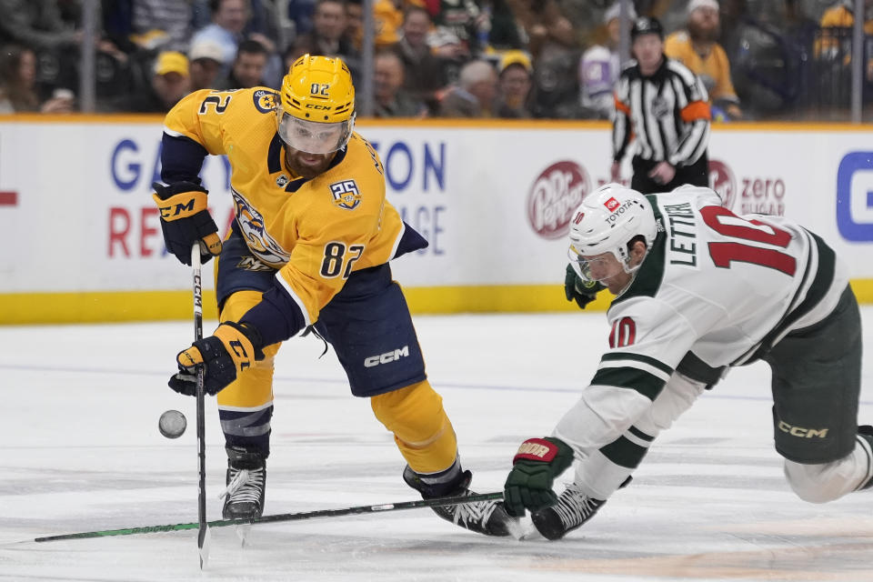 Nashville Predators center Tommy Novak (82) moves the puck past Minnesota Wild center Vinni Lettieri (10) during the second period of an NHL hockey game Thursday, Feb. 29, 2024, in Nashville, Tenn. (AP Photo/George Walker IV)