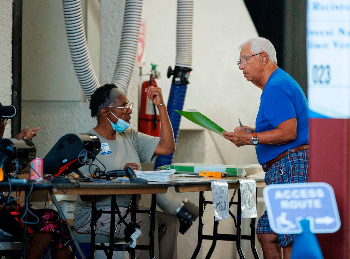 Poll workers assist a voter as votes cast during the Florida primary election at the Miami Beach Fire Department - Station 3 on Tuesday, Aug. 23, 2022, in Miami Beach, Florida.