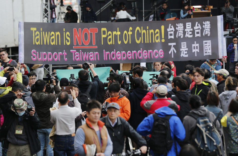 FILE - In this Jan. 16, 2016, file photo, pro-independence supporters carry a banner shouting that Taiwan is not part of China outside the Democratic Progressive Party presidential campaign headquarters in Taipei, Taiwan. The residents of this self-governing island are supporting their president Tsai Ing-wen as she stands up to China’s calls for unification with the mainland. (AP Photo/Wally Santana, File)