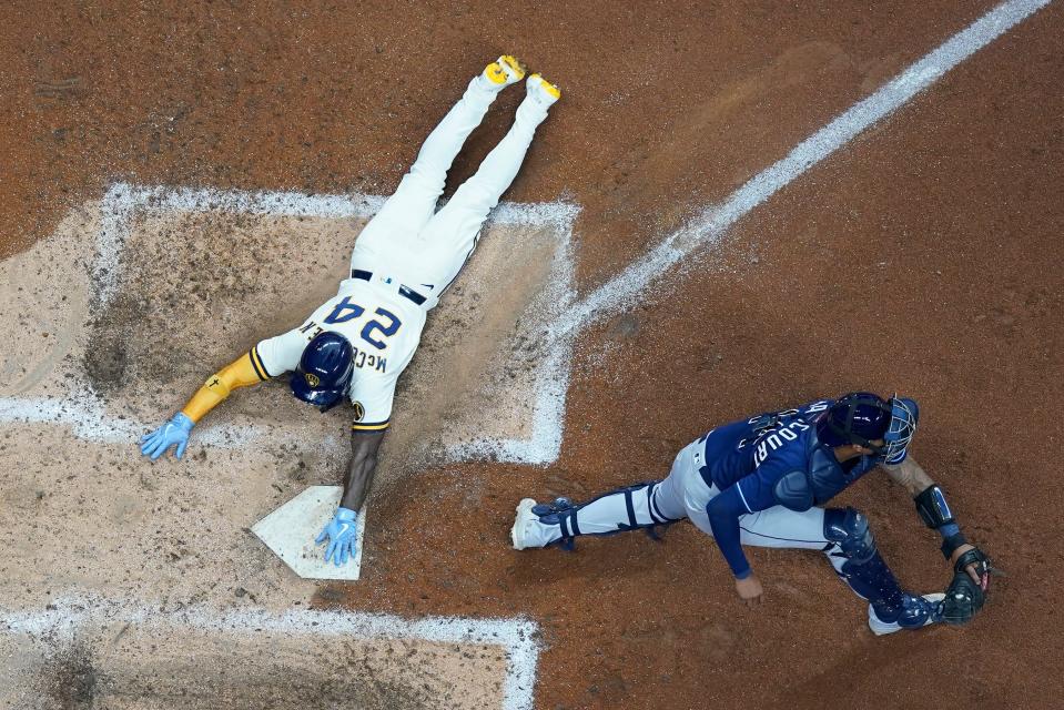 The Brewers' Andrew McCutchen scores past Rays catcher Christian Bethancourt during the fifth inning Tuesday night at American Family Field.