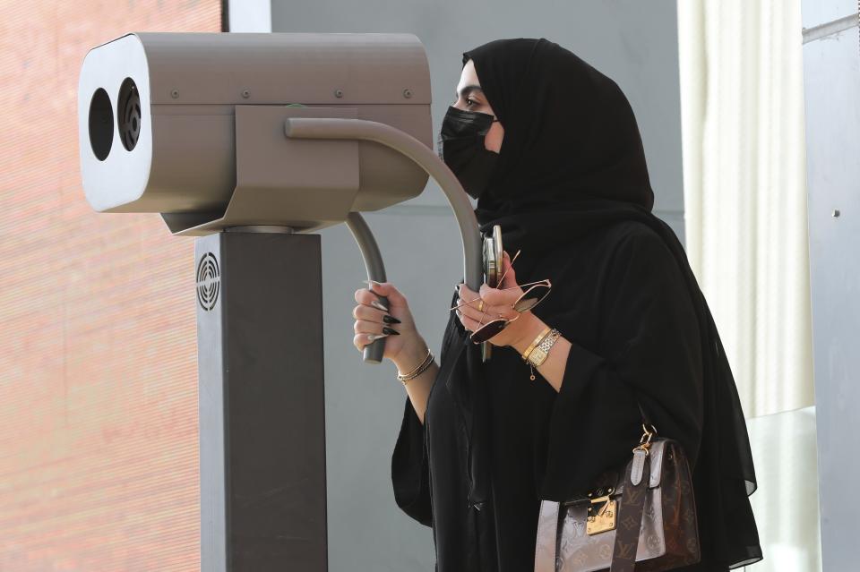 A journalist watch through a binocular during a media tour of the Israeli pavilion at the Dubai Expo in Dubai, United Arab Emirates, Monday, Sept. 27, 2021. Delayed a year over the coronavirus pandemic, Dubai's Expo 2020 opens this Friday. It will put this city-state all-in on its bet of billions of dollars that the world's fair will boost its economy. (AP Photo/Kamran Jebreili)