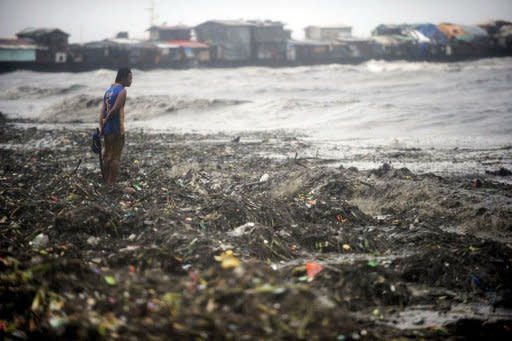 A man looks for usable materials amongst garbage washed up by strong waves caused by super-typhoon Nanmadol at a slum area beside Manila Bay. Super-typhoon Nanmadol killed at least seven people and left flattened bridges and blocked roads in its wake as it slowly moved away from the Philippines, officials said on Sunday