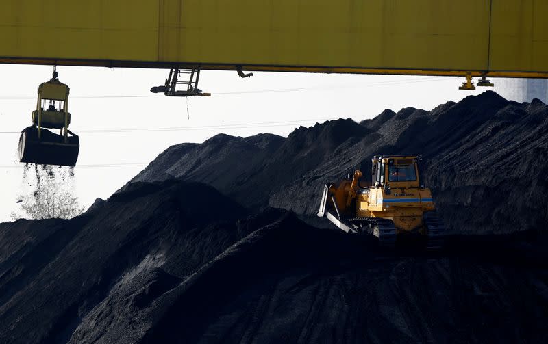 FILE PHOTO: A bulldozer works on a heap of coal at the Zeran Heat Power Plant in Warsaw