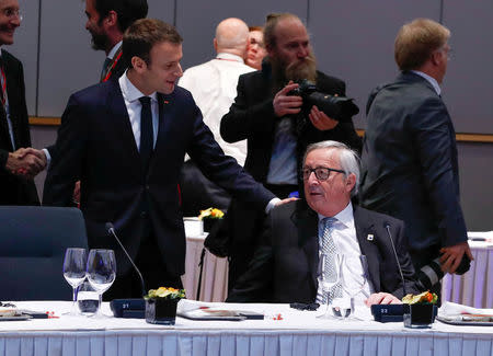 French President Emmanuel Macron talks with European Commission President Jean-Claude Juncker during a European Union leaders informal summit in Brussels, Belgium, February 23, 2018. REUTERS/Yves Herman