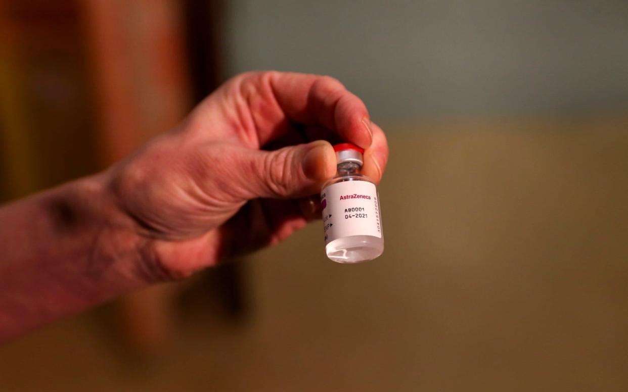 A nurse holds a vial of the Oxford vaccine before administering it in Oxford  - steve parsons/pa