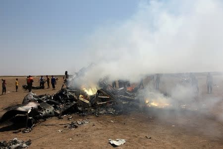 Rebel fighters and civilians inspect the wreckage of a Russian helicopter that had been shot down in the north of Syria's rebel-held Idlib province, Syria August 1, 2016. REUTERS/Ammar Abdullah