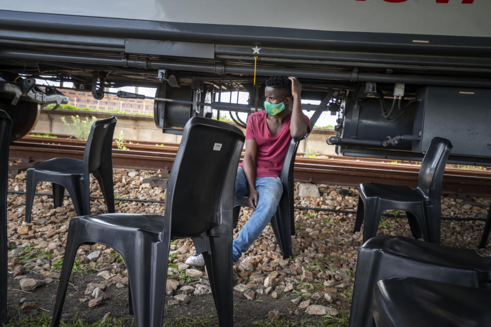 A person waits to receive a COVID-19 vaccination on a train parked at the Swartkops railroad yard outside Gqeberha, South Africa, Thursday Sept. 23, 2021. South Africa has sent a train carrying COVID-19 vaccines into one of its poorest provinces to get doses to areas where healthcare facilities are stretched. The vaccine train, named Transvaco, will go on a three-month tour through the Eastern Cape province and stop at seven stations for two weeks at a time to vaccinate people. (AP Photo/Jerome Delay)