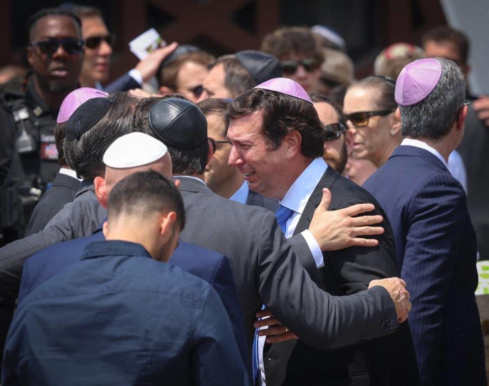 Men console family members after the funeral service for 15-year-old Ella Riley Adler held at Temple Beth Sholom on Monday, May 13, 2024, in Miami Beach, Florida.
