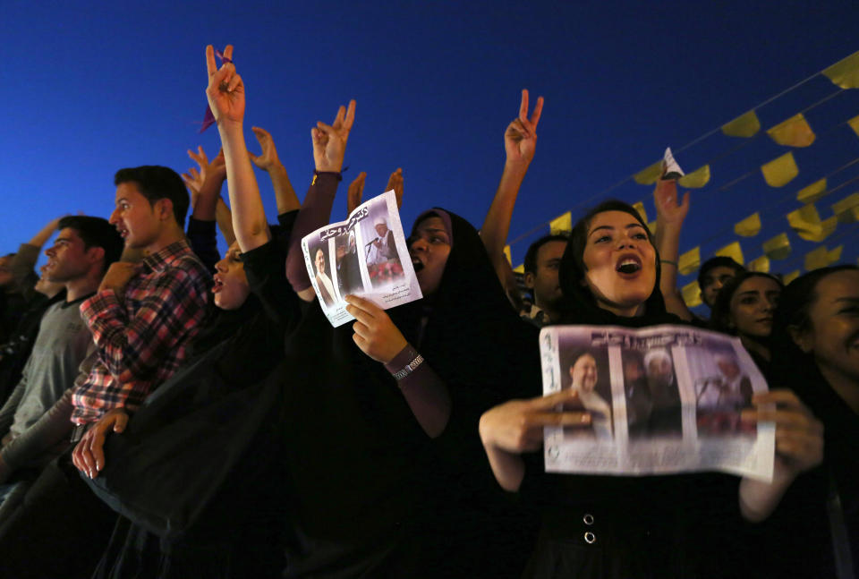 Iranians celebrate the victory of moderate presidential candidate Hassan Rouhani (portrait) in the presidential elections at Vanak Square, in northern Tehran, on June 15, 2013. (ATTA KENARE/AFP/Getty Images)