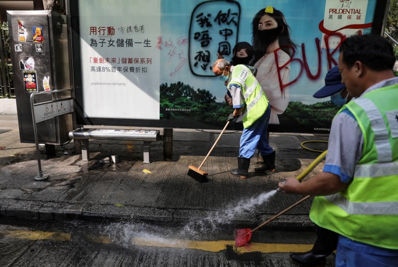 Cleaners wash a vandalized bus stop outside Kowloon Masjid and Islamic Centre in Hong Kong’s tourism district Tsim Sha Tsui