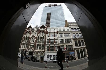 A man walks past suspended parking bays in front of the Walkie Talkie tower in London September 3, 2013. REUTERS/Stefan Wermuth/Files