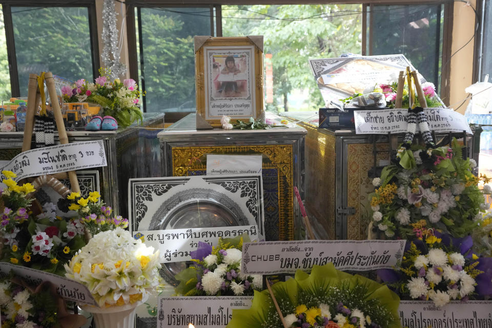 A photo of attack victim Siriprapa “Plai Fon” Prasertsuk is sits on top of her coffin inside the Wat Rat Samakee temple in the rural town of Uthai Sawan, north eastern Thailand, Saturday, Oct. 8, 2022. A former police officer burst into a day care center in northeastern Thailand on Thursday, killing dozens of preschoolers and teachers before shooting more people as he fled. (AP Photo/Sakchai Lalit)