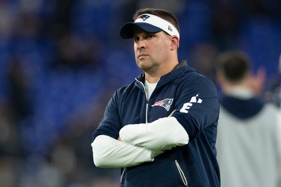 New England Patriots offensive coordinator Josh McDaniels stands on the field during warms up before the game against the Baltimore Ravens at M&T Bank Stadium.