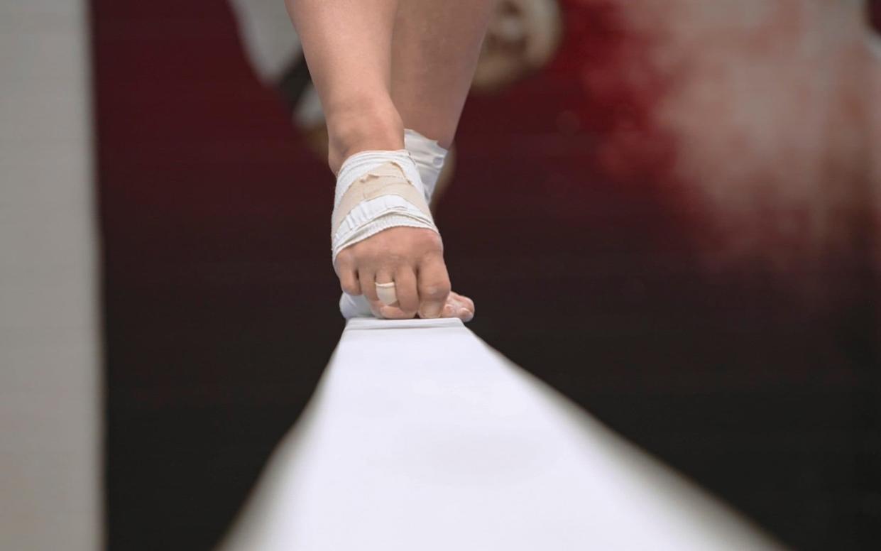 A gymnast's foot on a beam - Netflix via AP