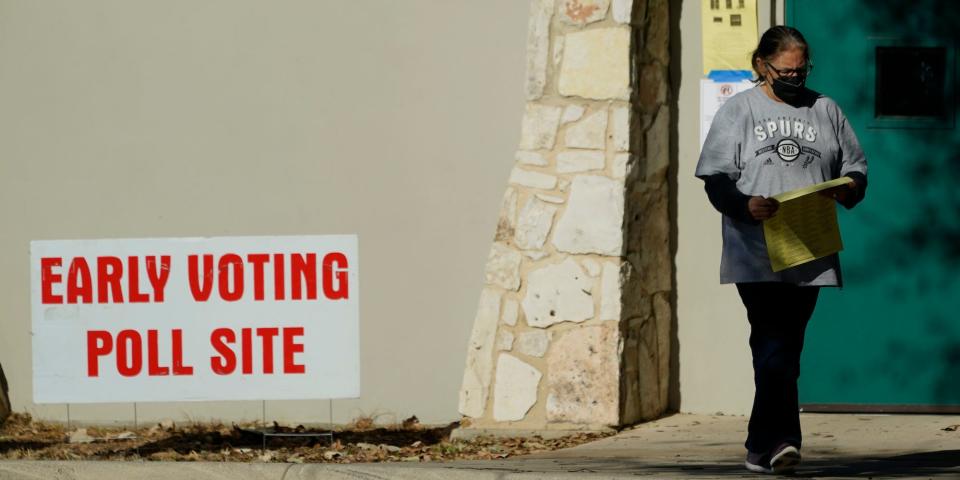 A woman exits an early voting poll site, Monday, Feb. 14, 2022, in San Antonio.