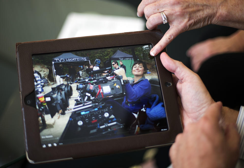 Elizabeth and Richard Jones, flip through photos of their daughter Sarah Jones, the 27-year-old camera assistant killed Feb. 20 by a freight train while filming a movie in southeast Georgia, as they sit in their attorney's office, Wednesday, April 9, 2014, in Atlanta. The couple say they’re grieving, angry and want someone held accountable for their daughter’s death. (AP Photo/David Goldman)