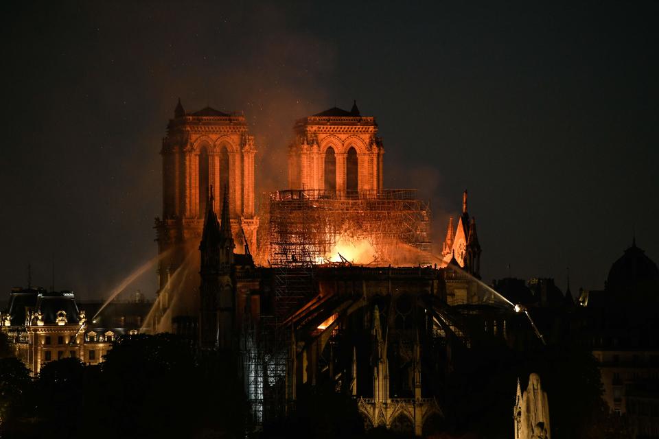 Firefighters douse flames burning the roof of the Notre Dame Cathedral in Paris on April 15, 2019.